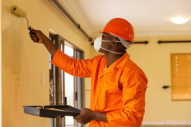 professional african construction worker painting the wall